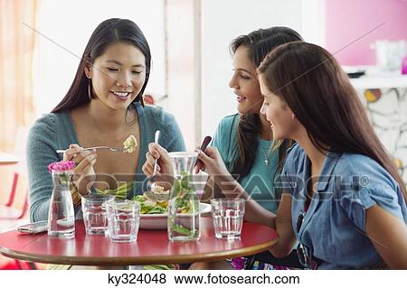 Three women eating food in a restaurant View Large Photo Image Stock Photo - Three women eating food in a restaurant. Fotosearch