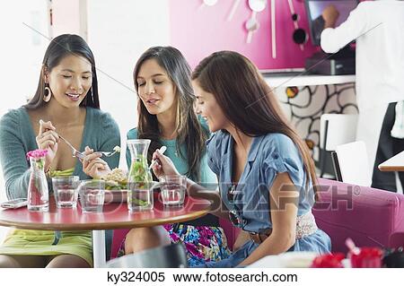 Three women eating food in a restaurant View Large Photo Image Stock Photography - Three women eating food in a restaurant. Fotosearch