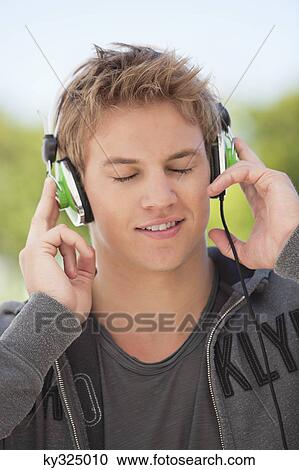 Man listening to music with headphones View Large Photo Image Stock Image - Man listening to music with headphones. Fotosearch