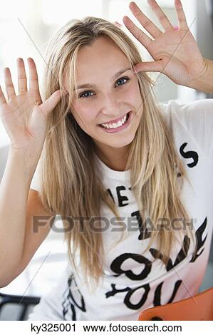 Stock Image - Portrait of a beautiful woman making a face at a cafe. Fotosearch