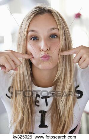 Stock Photography - Portrait of a beautiful woman making a face at a cafe. Fotosearch