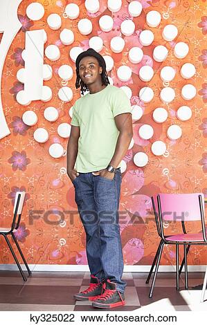 Portrait of a smiling man standing at a cafe View Large Photo Image Stock Image - Portrait of a smiling man standing at a cafe. Fotosearch
