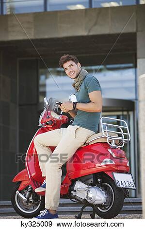Portrait of young man sitting on a scooter and text messaging View Large Photo Image Stock Photo - Portrait of young man sitting on a scooter and text messaging. Fotosearch