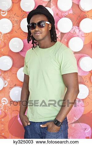 Smiling man wearing sunglasses and standing at a cafe View Large Photo Image Stock Image - Smiling man wearing sunglasses and standing at a cafe. Fotosearch