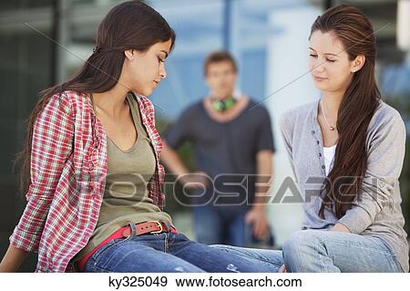 Two female friends sitting in a campus View Large Photo Image Stock Photo - Two female friends sitting in a campus. Fotosearch