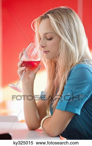 Young woman drinking red wine in a bar View Large Photo Image Stock Photography - Young woman drinking red wine in a bar. Fotosearch