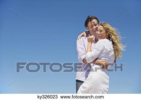 Couple embracing each other and smiling View Large Photo Image Stock Image - Couple embracing each other and smiling. Fotosearch