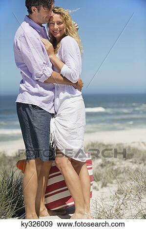 Couple embracing each other on the beach View Large Photo Image Stock Photo - Couple embracing each other on the beach. Fotosearch