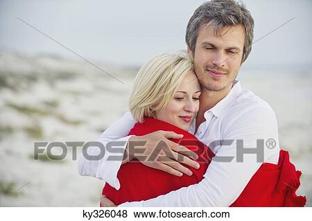 Couple embracing each other on the beach View Large Photo Image Stock Photo - Couple embracing each other on the beach. Fotosearch