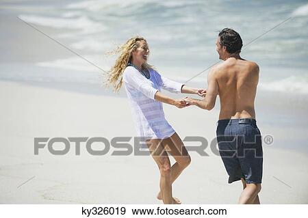 Stock Photo - Couple playing on the beach. Fotosearch