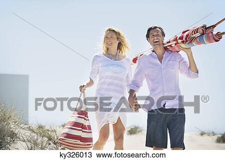 Couple walking on the beach View Large Photo Image Stock Image - Couple walking on the beach. Fotosearch