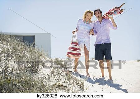 Couple walking on the beach View Large Photo Image Stock Photo - Couple walking on the beach. Fotosearch