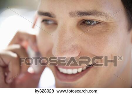 Close-up of a mid adult man talking on a mobile phone View Large Photo Image Stock Photo - Close-up of a mid adult man talking on a mobile phone. Fotosearch