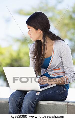 Close-up of a woman using a laptop View Large Photo Image Stock Image - Close-up of a woman using a laptop. Fotosearch