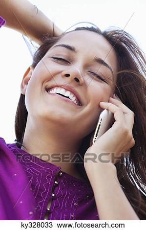 Stock Image - Close-up of a young woman talking on a mobile phone. Fotosearch