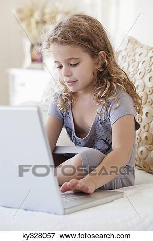 Cute little girl using a laptop in the bed View Large Photo Image Stock Photo - Cute little girl using a laptop in the bed. Fotosearch