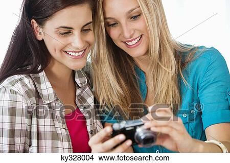 Female friends watching their picture in a camera View Large Photo Image Picture - Female friends watching their picture in a camera. Fotosearch