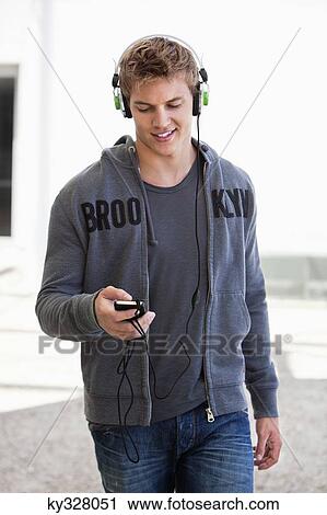 Man listening to music with headphones and smiling View Large Photo Image Stock Image - Man listening to music with headphones and smiling. Fotosearch