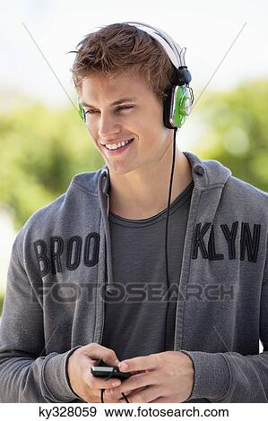Man listening to music with headphones and smiling View Large Photo Image Stock Photo - Man listening to music with headphones and smiling. Fotosearch