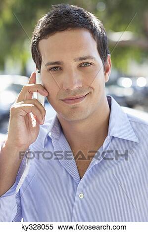Mid adult man talking on a mobile phone View Large Photo Image Stock Photography - Mid adult man talking on a mobile phone. Fotosearch