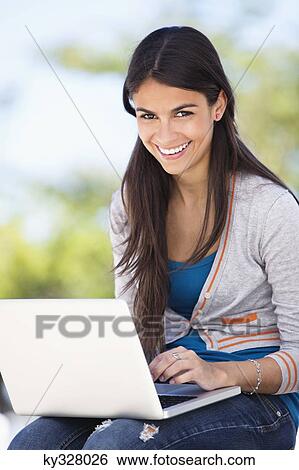 Portrait of a woman using a laptop and smiling View Large Photo Image Stock Photograph - Portrait of a woman using a laptop and smiling. Fotosearch