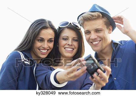 Three young people taking photo of themselves View Large Photo Image Stock Photo - Three young people taking photo of themselves. Fotosearch