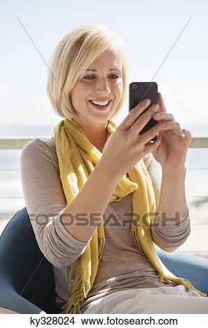 Woman text messaging on a mobile phone View Large Photo Image Picture - Woman text messaging on a mobile phone. Fotosearch
