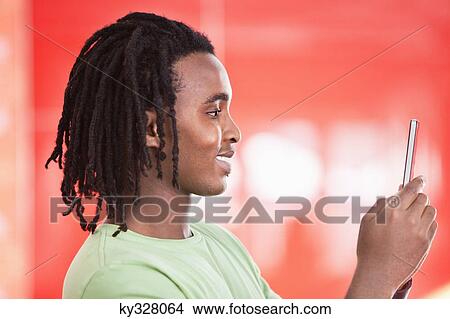 Young man taking a picture of himself with a mobile phone View Large Photo Image Picture - Young man taking a picture of himself with a mobile phone. Fotosearch