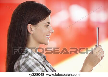 Young woman taking a picture of herself with a mobile phone View Large Photo Image Stock Photo - Young woman taking a picture of herself with a mobile phone. Fotosearch