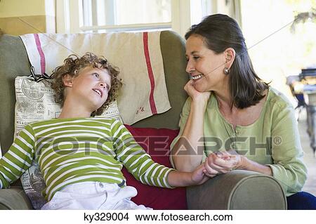 Grandmother and little boy sitting together at home View Large Photo Image Picture - Grandmother and little boy sitting together at home. Fotosearch