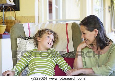 Grandmother and little boy sitting together at home View Large Photo Image Picture - Grandmother and little boy sitting together at home. Fotosearch