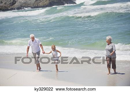 Senior couple enjoying on the beach with their granddaughter View Large Photo Image Stock Image - Senior couple enjoying on the beach with their granddaughter. Fotosearch