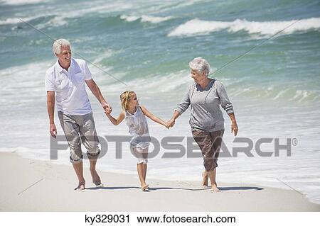 Senior couple walking with their granddaughter on the beach View Large Photo Image Stock Image - Senior couple walking with their granddaughter on the beach. Fotosearch