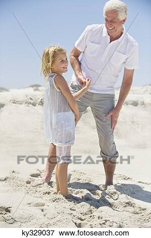 Senior man smiling with his granddaughter on the beach View Large Photo Image Stock Photo - Senior man smiling with his granddaughter on the beach. Fotosearch