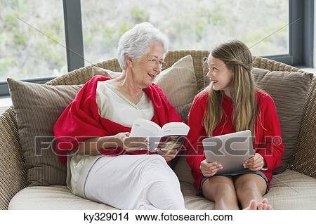 Senior woman and her granddaughter looking at each other and smiling View Large Photo Image Picture - Senior woman and her granddaughter looking at each other and smiling. Fotosearch