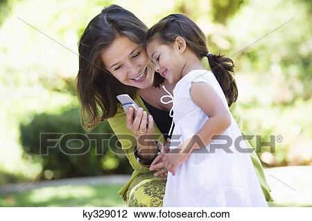 Woman and her granddaughter reading a text message View Large Photo Image Stock Image - Woman and her granddaughter reading a text message. Fotosearch