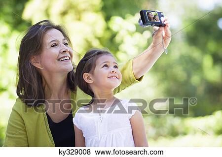 Woman and her granddaughter taking photos of themselves View Large Photo Image Stock Photo - Woman and her granddaughter taking photos of themselves. Fotosearch