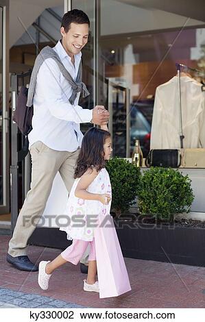 Cute little girl with her father walking out of a shopping mall with shopping bags View Large Photo Image Stock Image - Cute little girl with her father walking out of a shopping mall with shopping bags. Fotosearch