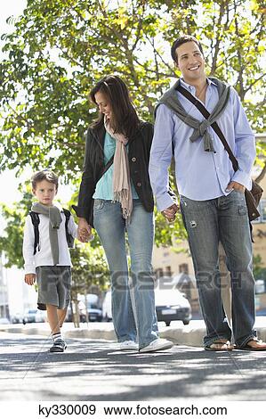 Stock Photo - Family walking together on the road. Fotosearch
