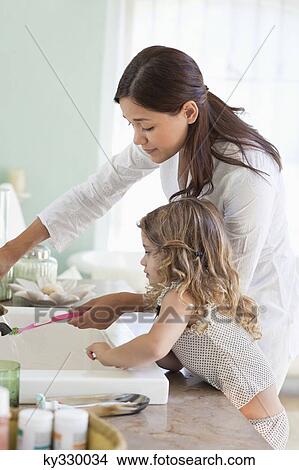 Mother and little girl washing tooth brush View Large Photo Image Picture - Mother and little girl washing tooth brush. Fotosearch