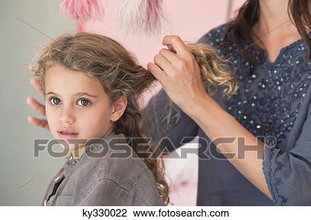 Mother styling her daughter's hair View Large Photo Image Stock Image - Mother styling her daughter's hair. Fotosearch