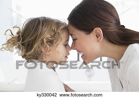 Mother touching nose with little girl wrapped in towel at bathroom View Large Photo Image Stock Image - Mother touching nose with little girl wrapped in towel at bathroom. Fotosearch