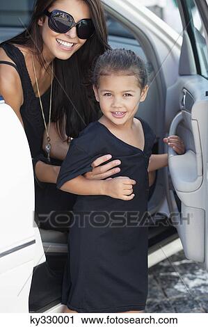 Portrait of a beautiful young woman with her cute daughter sitting in a car View Large Photo Image Stock Image - Portrait of a beautiful young woman with her cute daughter sitting in a car. Fotosearch