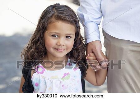 Stock Image - Portrait of a little girl holding her father's hand. Fotosearch