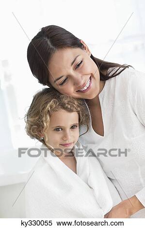 Portrait of a woman hugging her daughter wrapped in towel View Large Photo Image Stock Photography - Portrait of a woman hugging her daughter wrapped in towel. Fotosearch