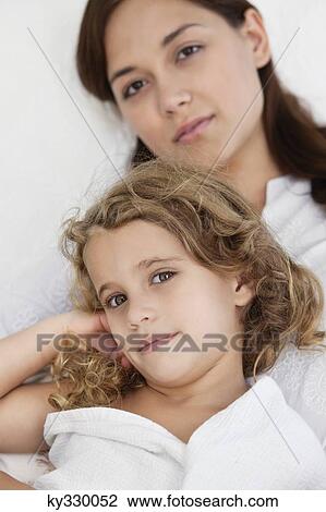 Portrait of a young woman lying with her daughter wrapped in white towel View Large Photo Image Stock Image - Portrait of a young woman lying with her daughter wrapped in white towel. Fotosearch