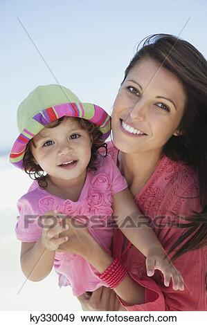 Stock Photo - Woman enjoying on the beach with her daughter. Fotosearch