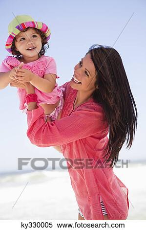 Woman enjoying on the beach with her daughter View Large Photo Image Stock Photography - Woman enjoying on the beach with her daughter. Fotosearch