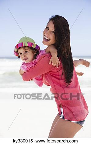 Woman enjoying on the beach with her daughter View Large Photo Image Stock Photography - Woman enjoying on the beach with her daughter. Fotosearch