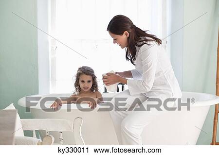 Stock Image - Woman giving a bath to her daughter. Fotosearch